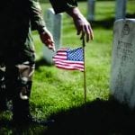 soldier placing grave stone flag