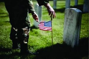 soldier placing grave stone flag